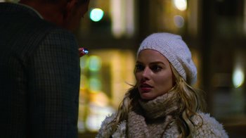 Movie still from “Focus” (2015), directed by John Requa – A woman wearing a white hat and a white scarf; Close Up shot, Over the shoulder angle