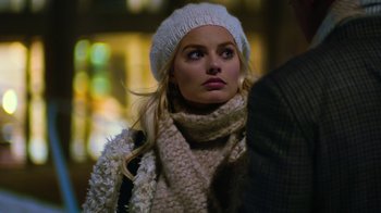Movie still from “Focus” (2015), directed by John Requa – A woman wearing a white hat and a white scarf; Close Up shot, Over the shoulder angle