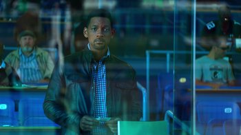 Movie still from “Focus” (2015), directed by John Requa – A man standing in front of a glass window; Close Up shot, Over the shoulder angle