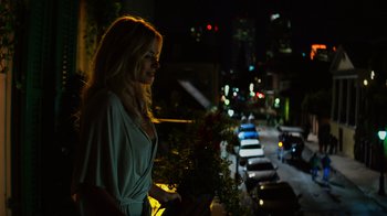 Movie still from “Focus” (2015), directed by John Requa – A woman standing on the side of a road at night; Medium shot, Over the shoulder angle