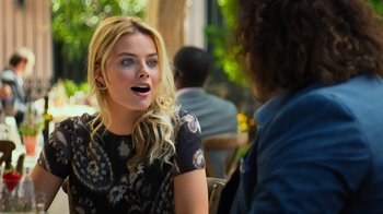 Movie still from “Focus” (2015), directed by John Requa – A woman sitting in front of a man at an outdoor cafe; Close Up shot, Over the shoulder angle