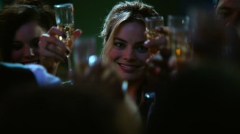 Movie still from “Focus” (2015), directed by John Requa – A group of people holding up glasses of wine; Close Up shot, Over the shoulder angle