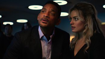 Movie still from “Focus” (2015), directed by John Requa – A man and a woman standing next to each other in a room; Close Up shot, Low angle