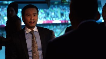 Movie still from “Focus” (2015), directed by John Requa – A man wearing a suit and tie talking to another man in a suit; Close Up shot, Over the shoulder angle