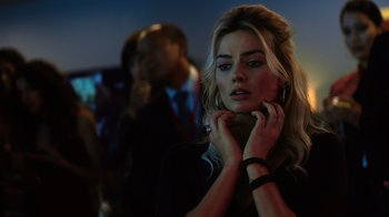 Movie still from “Focus” (2015), directed by John Requa – A beautiful blonde woman with a black shirt; Close Up shot, Over the shoulder angle