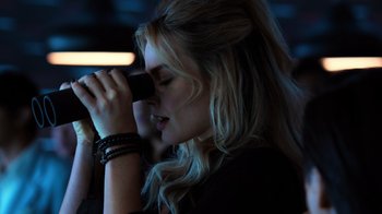 Movie still from “Focus” (2015), directed by John Requa – A beautiful blond haired woman taking a picture with a camera; Close Up shot, Over the shoulder angle
