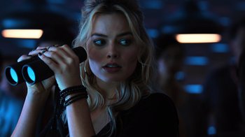 Movie still from “Focus” (2015), directed by John Requa – A beautiful blonde woman holding a cell phone; Close Up shot, Over the shoulder angle