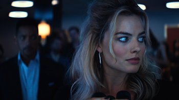 Movie still from “Focus” (2015), directed by John Requa – A beautiful blonde woman with blue eyes and long blonde hair; Close Up shot, Over the shoulder angle