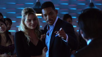 Movie still from “Focus” (2015), directed by John Requa – A man and a woman posing for a picture in a nightclub; Medium shot, Over the shoulder angle