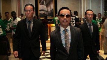 Movie still from “Focus” (2015), directed by John Requa – A man in a suit and tie standing next to another man in a suit and tie; Medium shot, Low angle