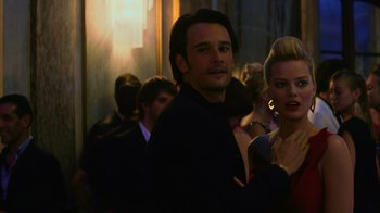 Movie still from “Focus” (2015), directed by John Requa – A man and a woman standing next to each other in a room; Close Up shot, Over the shoulder angle