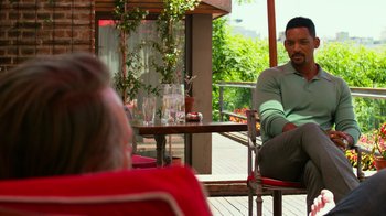 Movie still from “Focus” (2015), directed by John Requa – A man sitting at a table in front of a woman; Medium shot, Over the shoulder angle