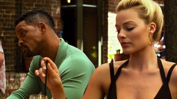 Movie still from “Focus” (2015), directed by John Requa – A man and a woman sitting next to each other at a table; Close Up shot, Low angle