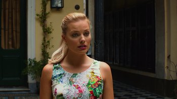Movie still from “Focus” (2015), directed by John Requa – A woman with blonde hair wearing a colorful dress; Close Up shot, Over the shoulder angle