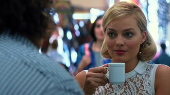 Movie still from “Focus” (2015), directed by John Requa – A woman holding a coffee cup in her hand; Close Up shot, Over the shoulder angle