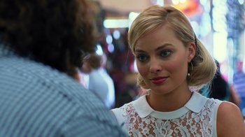 Movie still from “Focus” (2015), directed by John Requa – A beautiful young blonde woman wearing a white dress; Close Up shot, Over the shoulder angle