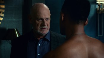 Movie still from “Focus” (2015), directed by John Requa – An older man looking into a mirror while standing next to a younger man; Medium shot, Over the shoulder angle
