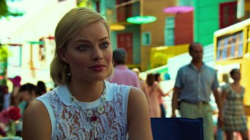 Movie still from “Focus” (2015), directed by John Requa – A beautiful blonde woman sitting in a chair; Close Up shot, Over the shoulder angle