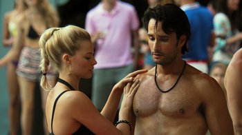 Movie still from “Focus” (2015), directed by John Requa – A man and a woman standing next to each other; Close Up shot, Over the shoulder angle