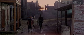 Movie still from “For a Few Dollars More” (1965), directed by Sergio Leone – Two men on horseback walking down a dirt road; Wide shot, Low angle