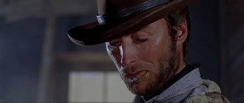 Movie still from “For a Few Dollars More” (1965), directed by Sergio Leone – A person wearing a hat and smoking a cigarette; Close Up shot, Low angle
