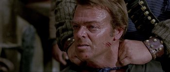 Movie still from “For a Few Dollars More” (1965), directed by Sergio Leone – A person with a knife on his face; Close Up shot, Over the shoulder angle