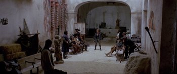 Movie still from “For a Few Dollars More” (1965), directed by Sergio Leone – A group of people sitting around a room; Wide shot, High angle