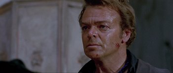 Movie still from “For a Few Dollars More” (1965), directed by Sergio Leone – A person with a knife on his face; Close Up shot, Over the shoulder angle