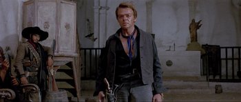 Movie still from “For a Few Dollars More” (1965), directed by Sergio Leone – A man standing in front of an easel in a room; Medium shot, Low angle