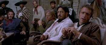 Movie still from “For a Few Dollars More” (1965), directed by Sergio Leone – A group of people sitting in a room; Medium shot, Low angle