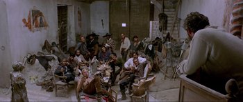 Movie still from “For a Few Dollars More” (1965), directed by Sergio Leone – A group of men sitting around in a room; Wide shot, High angle