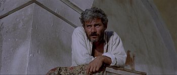 Movie still from “For a Few Dollars More” (1965), directed by Sergio Leone – A person leaning on a wall; Close Up shot, Low angle
