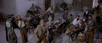 Movie still from “For a Few Dollars More” (1965), directed by Sergio Leone – A group of men sitting around a table; Wide shot, High angle