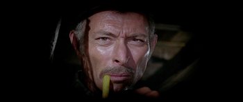 Movie still from “For a Few Dollars More” (1965), directed by Sergio Leone – An older man with a stick in his mouth; Close Up shot, Low angle