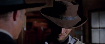 Movie still from “For a Few Dollars More” (1965), directed by Sergio Leone – A man with a hat and a beard looking to his left; Close Up shot, Low angle