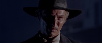 Movie still from “For a Few Dollars More” (1965), directed by Sergio Leone – A person wearing a suit and a hat; Close Up shot, Low angle