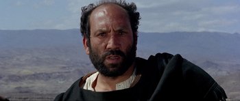 Movie still from “For a Few Dollars More” (1965), directed by Sergio Leone – A man with a beard and a black shirt; Close Up shot, Low angle