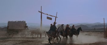Movie still from “For a Few Dollars More” (1965), directed by Sergio Leone – A group of people riding horses on a dirt field; Extreme Wide shot, Low angle