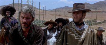 Movie still from “For a Few Dollars More” (1965), directed by Sergio Leone – A group of men standing next to each other in a field; Medium shot, Low angle