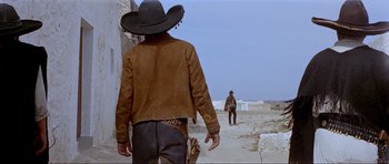 Movie still from “For a Few Dollars More” (1965), directed by Sergio Leone – A man in a cowboy hat walking down a street; Wide shot, Low angle