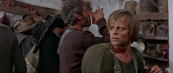 Movie still from “For a Few Dollars More” (1965), directed by Sergio Leone – A man with his hand up to his face; Close Up shot, Low angle