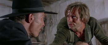 Movie still from “For a Few Dollars More” (1965), directed by Sergio Leone – A man and a man in a hat looking at each other; Close Up shot, Over the shoulder angle