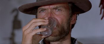 Movie still from “For a Few Dollars More” (1965), directed by Sergio Leone – A person drinking a glass of water; Close Up shot, Low angle