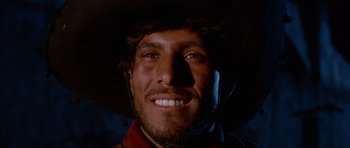Movie still from “For a Few Dollars More” (1965), directed by Sergio Leone – A person wearing a cowboy hat smiling; Close Up shot, Low angle