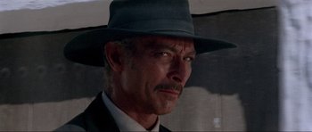 Movie still from “For a Few Dollars More” (1965), directed by Sergio Leone – A person wearing a hat and a suit; Close Up shot, Low angle