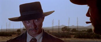 Movie still from “For a Few Dollars More” (1965), directed by Sergio Leone – A person wearing a hat and a suit; Close Up shot, Low angle