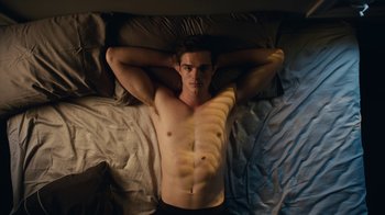 Movie still from “Euphoria” (2019), created by Sam Levinson – A man laying in bed with his hands behind his head; Medium shot, Overhead angle