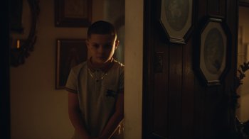 Movie still from “Euphoria” (2019), created by Sam Levinson – A young boy standing in front of a door; Medium shot, Over the shoulder angle