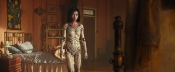 Movie still from “Alita: Battle Angel” (2019), directed by Robert Rodriguez – A woman standing next to a bed in a room; Medium shot, Low angle