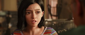 Movie still from “Alita: Battle Angel” (2019), directed by Robert Rodriguez – A person wearing a striped shirt; Close Up shot, Over the shoulder angle